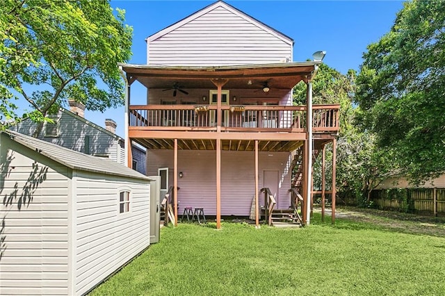 rear view of property featuring a deck, ceiling fan, and a lawn