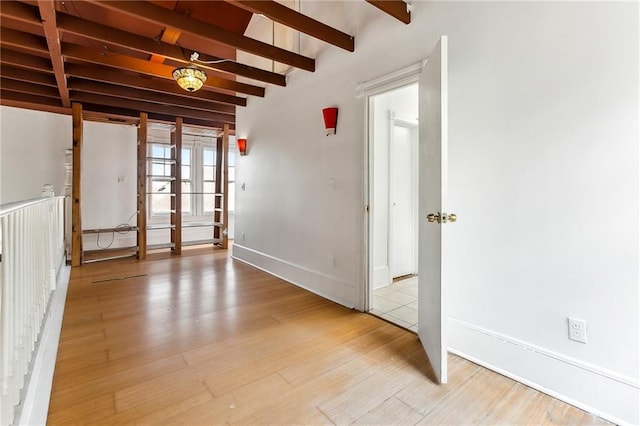 unfurnished room with beam ceiling, french doors, and light hardwood / wood-style flooring