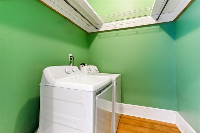 washroom with hardwood / wood-style floors and separate washer and dryer