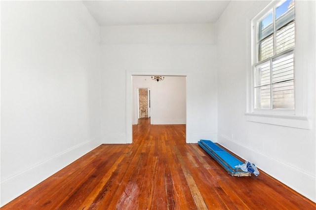 unfurnished room featuring hardwood / wood-style flooring and a notable chandelier