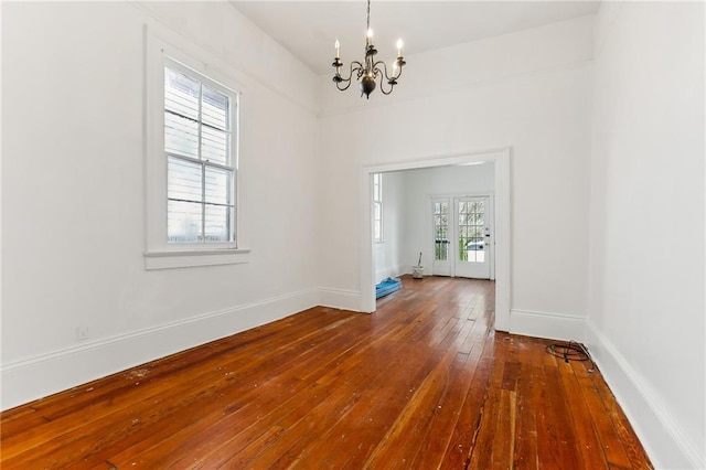 unfurnished dining area featuring hardwood / wood-style flooring and an inviting chandelier