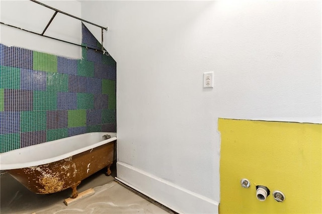 bathroom featuring concrete flooring and a tub to relax in