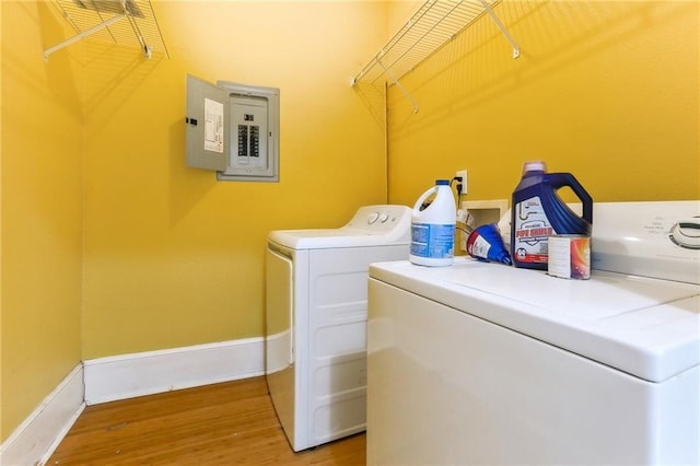 laundry room featuring hardwood / wood-style floors, electric panel, and washing machine and clothes dryer