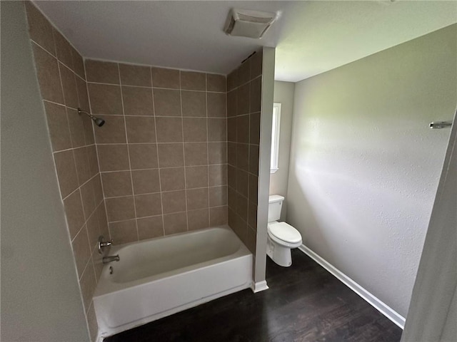 bathroom featuring hardwood / wood-style floors, toilet, and tiled shower / bath