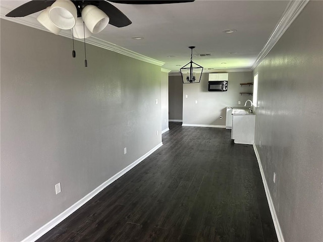 hall with an inviting chandelier, crown molding, dark wood-type flooring, and sink