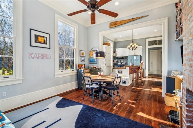 dining area with ceiling fan with notable chandelier, dark hardwood / wood-style flooring, and crown molding