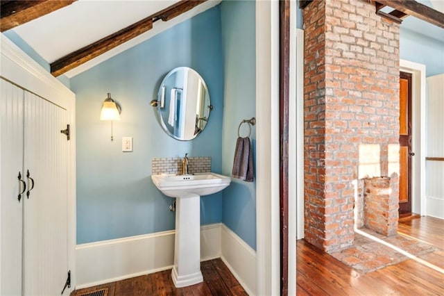 bathroom featuring vaulted ceiling with beams and hardwood / wood-style flooring