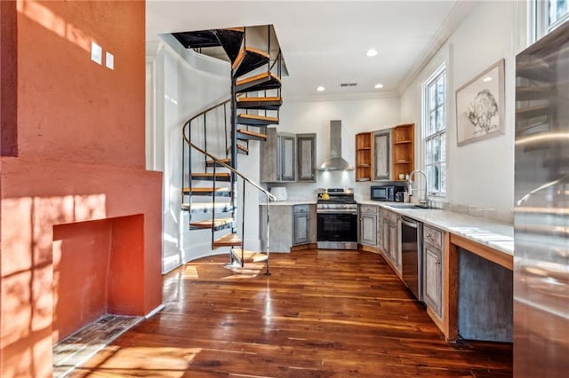 kitchen with appliances with stainless steel finishes, wall chimney exhaust hood, crown molding, sink, and dark hardwood / wood-style floors