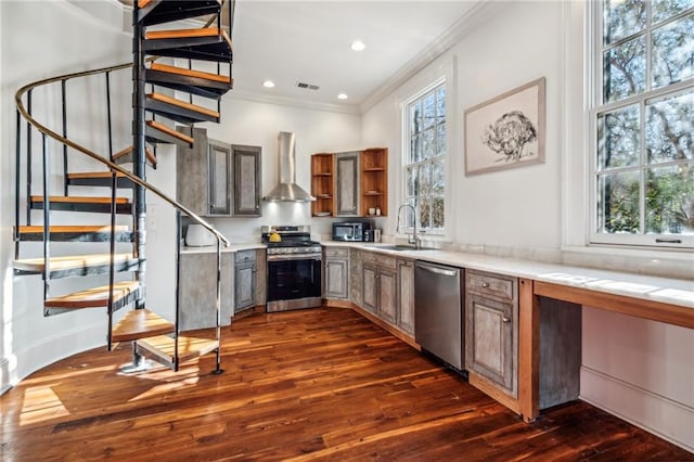 kitchen with a wealth of natural light, dark hardwood / wood-style flooring, wall chimney exhaust hood, and stainless steel appliances