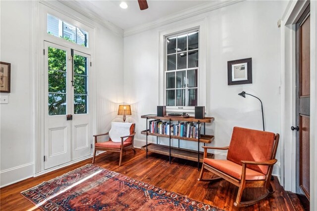 living area with french doors, hardwood / wood-style flooring, ceiling fan, and crown molding