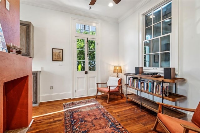 sitting room featuring hardwood / wood-style flooring, ceiling fan, and crown molding