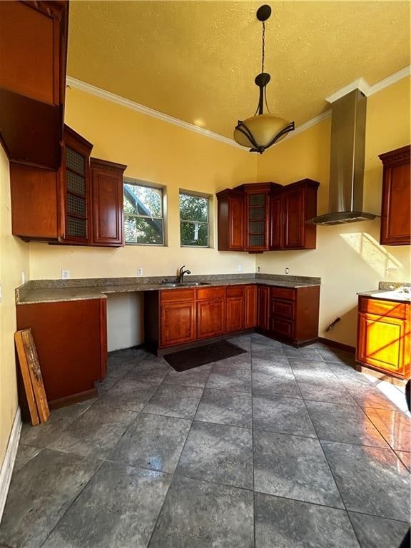 kitchen featuring wall chimney exhaust hood, sink, crown molding, and decorative light fixtures