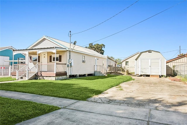 view of property exterior with a porch, a yard, and a storage shed