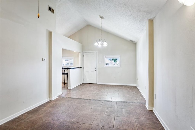 foyer featuring high vaulted ceiling, a textured ceiling, and an inviting chandelier