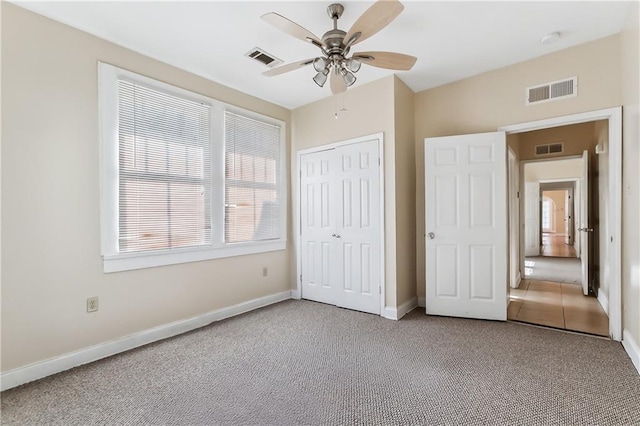 unfurnished bedroom with ceiling fan, carpet floors, and a closet