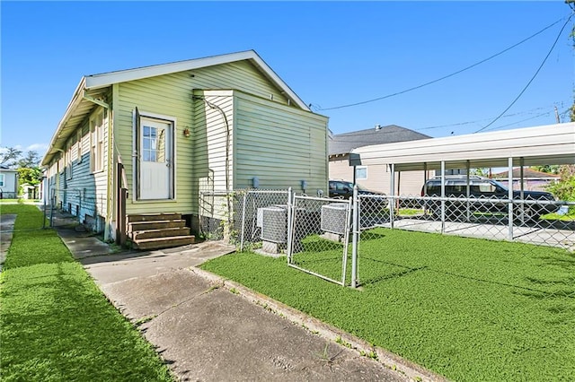 view of home's exterior with a carport and a yard