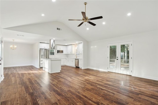 unfurnished living room featuring french doors, ceiling fan with notable chandelier, dark hardwood / wood-style floors, and high vaulted ceiling