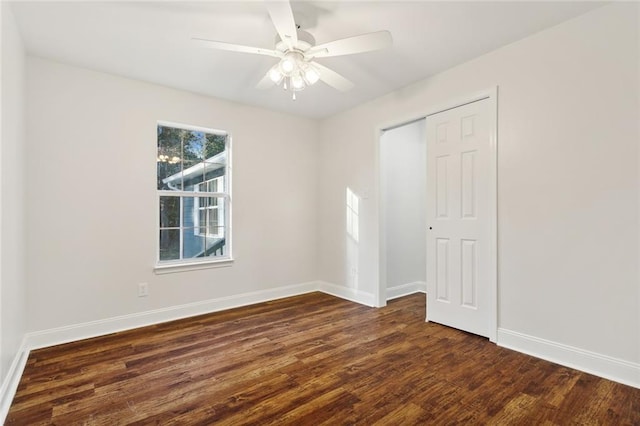 empty room with dark hardwood / wood-style floors and ceiling fan