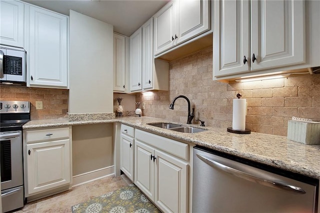 kitchen featuring a sink, appliances with stainless steel finishes, tasteful backsplash, and white cabinets