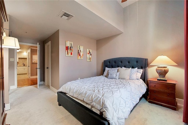 bedroom featuring visible vents, baseboards, and light carpet