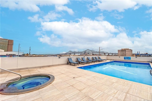 pool featuring fence, a patio, and a hot tub