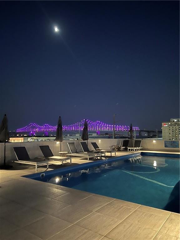 pool at night with a patio area