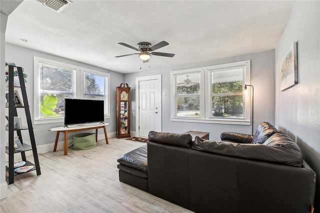 living room featuring ceiling fan and a healthy amount of sunlight