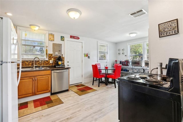 kitchen featuring dishwasher, sink, light hardwood / wood-style flooring, decorative backsplash, and white fridge