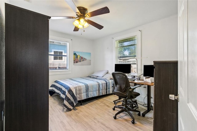 bedroom with ceiling fan, light wood-type flooring, and multiple windows