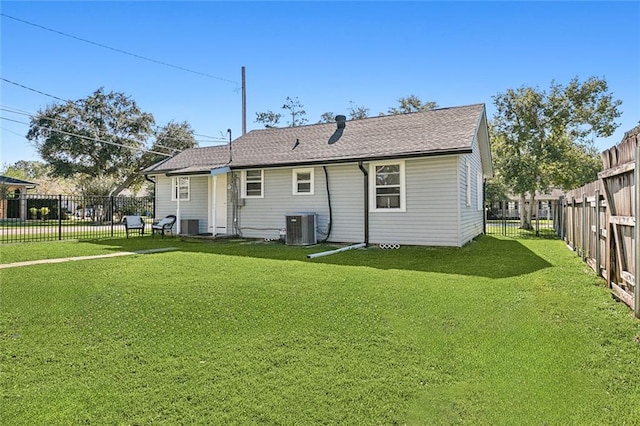 rear view of house with a yard and central AC