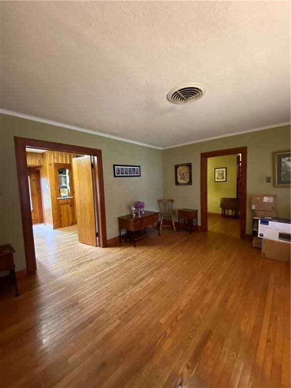 interior space with light hardwood / wood-style flooring and crown molding