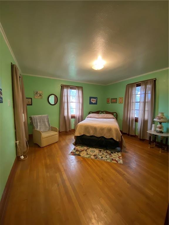 bedroom featuring hardwood / wood-style floors and ornamental molding