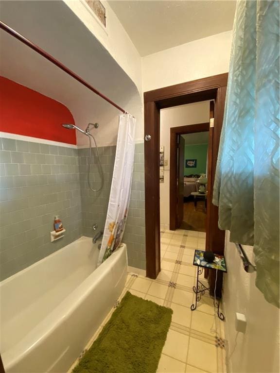 bathroom featuring shower / bathtub combination with curtain and tile walls