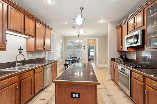 kitchen featuring sink, stainless steel appliances, a kitchen island, pendant lighting, and light tile patterned flooring