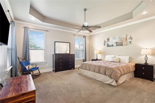 bedroom featuring multiple windows, a tray ceiling, and ceiling fan