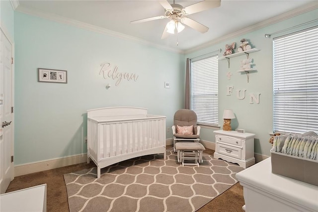 carpeted bedroom featuring multiple windows, ceiling fan, a crib, and ornamental molding