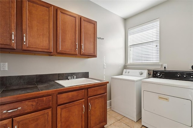 laundry area featuring cabinets, sink, light tile patterned flooring, and washer and dryer