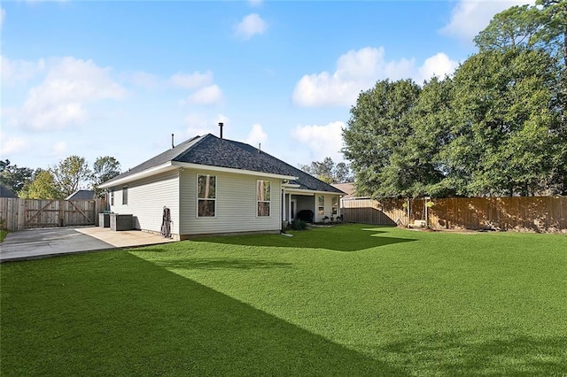 rear view of house with cooling unit, a yard, and a patio