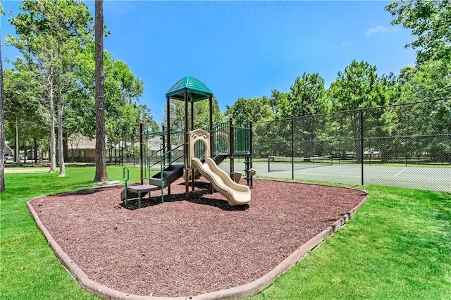 view of play area featuring a lawn and tennis court