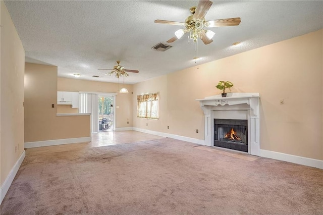 unfurnished living room with a textured ceiling, ceiling fan, and light carpet