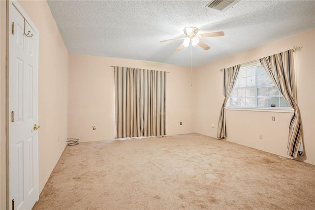 carpeted spare room with ceiling fan and a textured ceiling