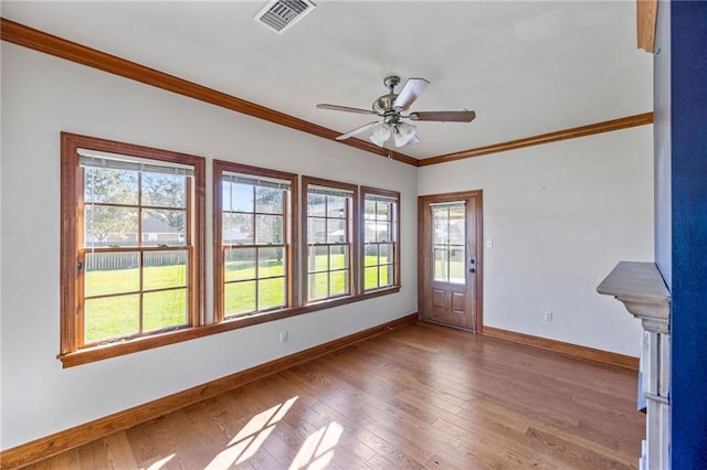 interior space featuring hardwood / wood-style flooring, plenty of natural light, and crown molding