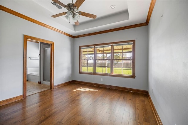 unfurnished room featuring hardwood / wood-style floors, a raised ceiling, ceiling fan, and crown molding