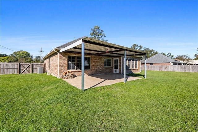 back of house with a lawn and a patio area