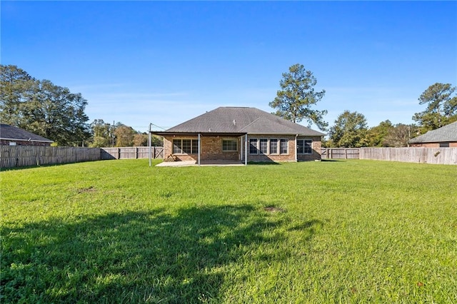 rear view of property with a yard and a patio