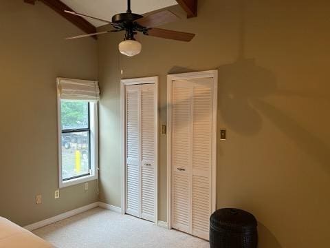 unfurnished bedroom with ceiling fan, light carpet, and multiple closets