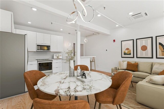 interior space featuring recessed lighting, baseboards, light wood finished floors, and visible vents