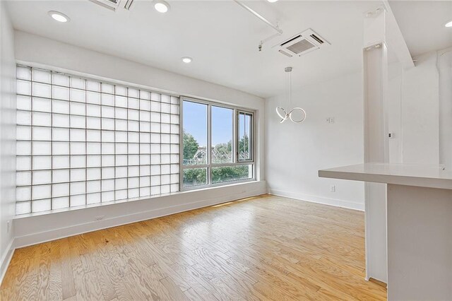 kitchen featuring light countertops, white cabinets, hanging light fixtures, and visible vents