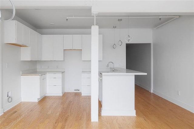kitchen featuring white cabinetry, light countertops, decorative light fixtures, and visible vents