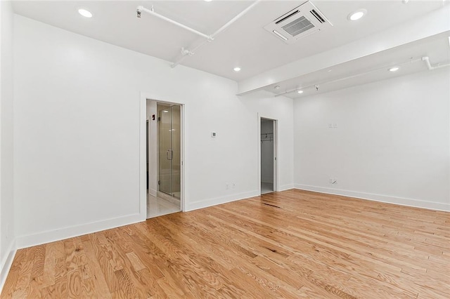 spare room featuring light wood-style flooring, recessed lighting, baseboards, and visible vents